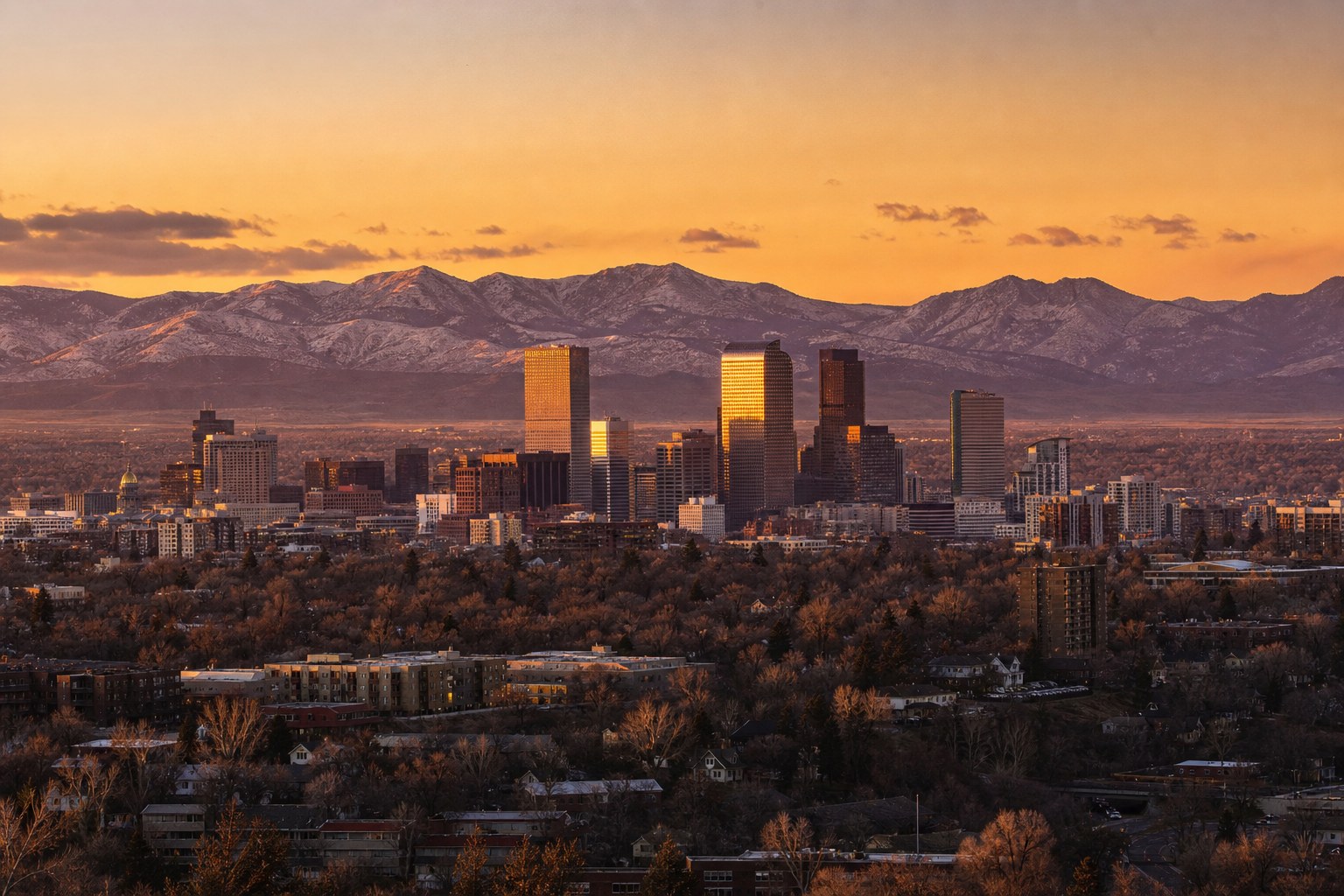 The Denver skyline with the Rocky Mountains behind it at sunset, illustrative